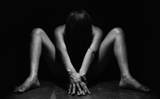 Woman stretching legs in dark room